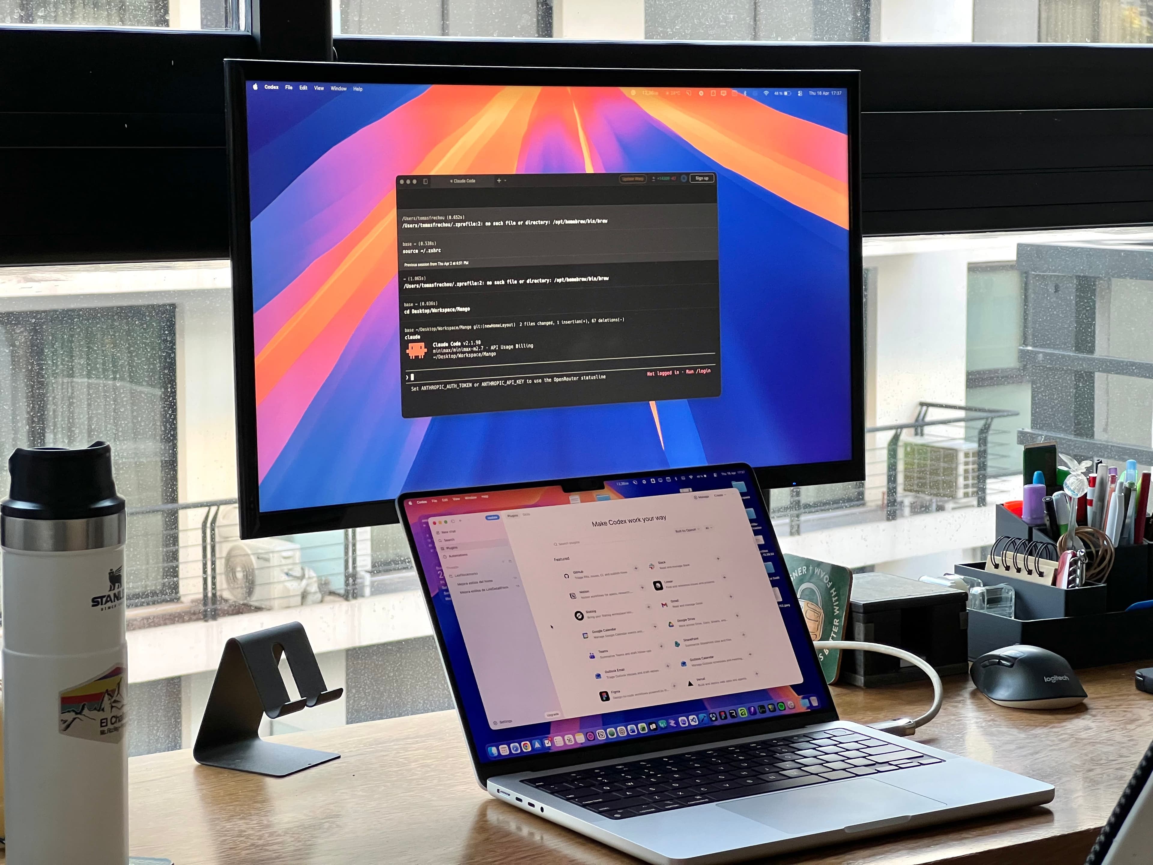 Desk with a laptop and monitor running AI development tools
